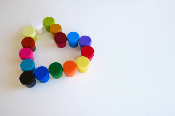 istock Jars with multi-colored paints in the shape of a heart. Creative background. Paint for drawing. Love postcard. Mock up 1388403822