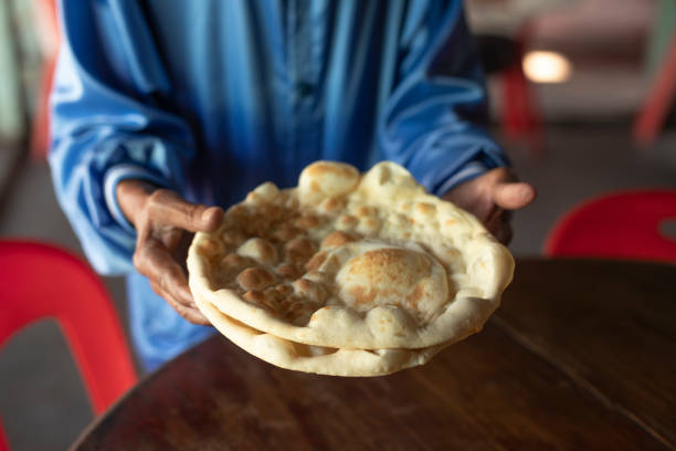 Naan Roti old man serve Naan Roti to customers at the traditional coffee shop Roti with Ghee stock pictures, royalty-free photos & images