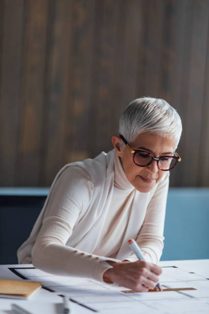 istock Elegant Senior Woman Architect Working on her Project in the Office 1388405662