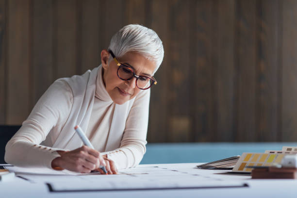istock Elegant Senior Woman Architect Working on her Project in the Office 1388405663