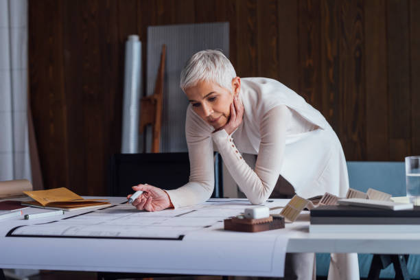 Elegant Senior Woman Architect Working on her Project in the Office