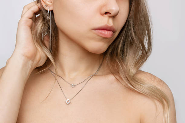 przycięte ujęcie młodej kobiety w eleganckich diamentowych kolczykach i srebrnym łańcuszku z wisiorkiem - diamond earrings zdjęcia i obrazy z banku zdjęć