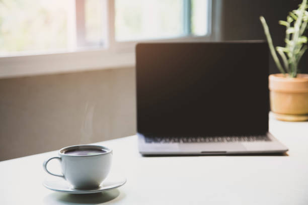 istock White of aroma coffee cup on the table with laptop ready to work for drink caffeine working home office in the morning, Energy drink before starting work concept. close up 1388409332