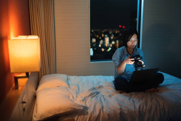 istock Freelancer photographer checking photos and working on laptop at night 1388409383