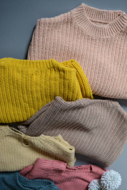 istock Various colors baby sweaters on dark gray background 1388409413