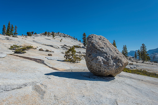 Glacial erratic rock on a granite dome at Olmsted Point in Yosemite National Park, California. Sierra Nevada Mountains. Deposited by a glacier ice.