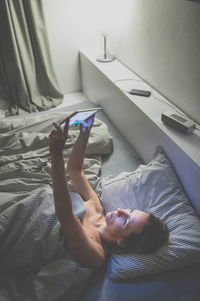 istock Middle-aged woman using her tablet computer before sleep in bed in the evening 1388410962