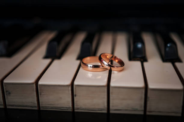 istock Pair of gold wedding rings on a piano 1388411090