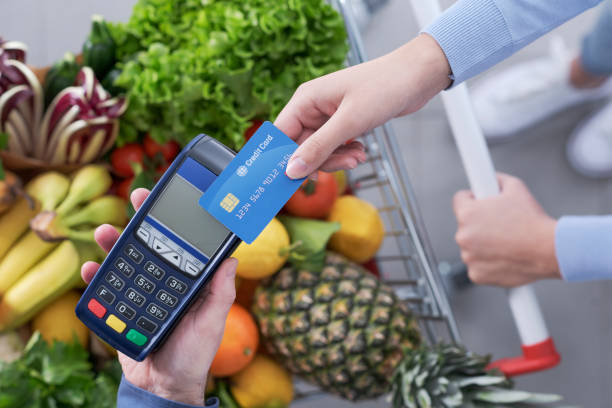 istock Woman paying for groceries using a credit card 1388413422