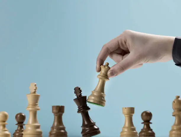 Player defeating his opponent and winning a chess game, leadership and power concept