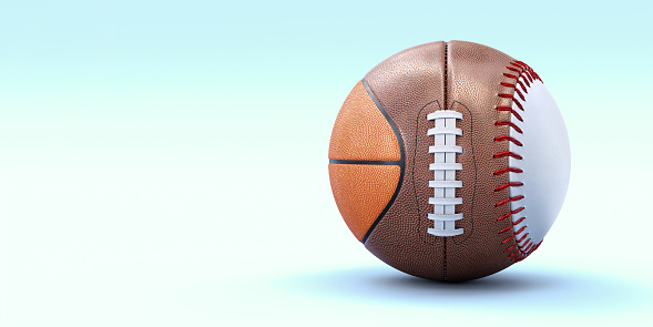 A fake spherical sports ball made from parts of a basketball, American football and baseball. The ball sits on a plain light blue background with lots of copy space.