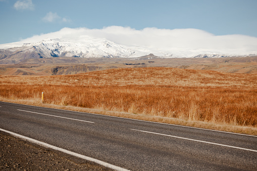 asphalt road and snowcapped mountains in southern iceland, nordic islands, europe.