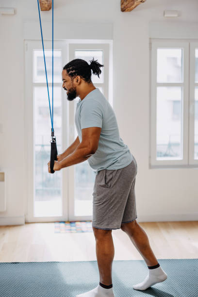 istock Home workout routine. Black man doing suspension straps exercises 1388419214