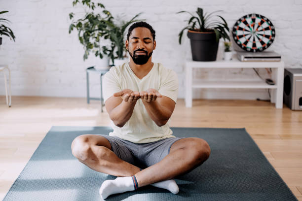 istock Young black man meditating in his appartment. Breathing technique. 1388419308