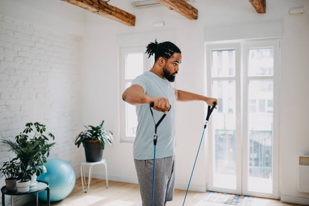 home-workout-routine. schwarzer mann macht suspension straps übungen - krafttraining stock-fotos und bilder