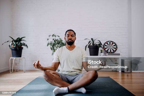 Fitness Meditation And Healthy Lifestyle Concept Black Man Meditating In Lotus Pose On Exercise Mat At Home Stock Photo - Download Image Now