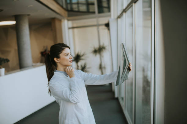 istock Yyoung female doctos examining x-ray image in the office 1388420563