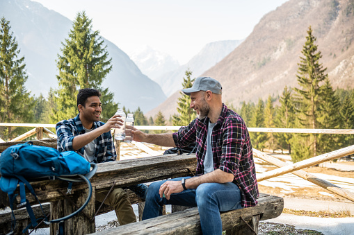 Two man resting and drinking water at the end of the hike in Julian Alps, Slovenia, Europe.