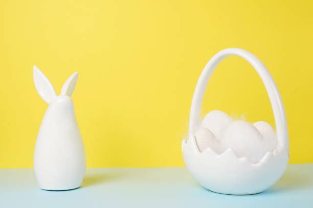 istock Easter greeting card bunny and basket with eggs on yellow background. Easter card with copy space for text 1388422863