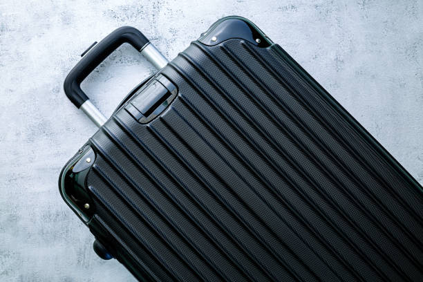 istock black travel bag,Black luggage set on dark background, top view image, flat lay composition. Travel minimalist concept, black and dark classic baggage mockup, small and big. Suitcase accessory set, journey 1388423156