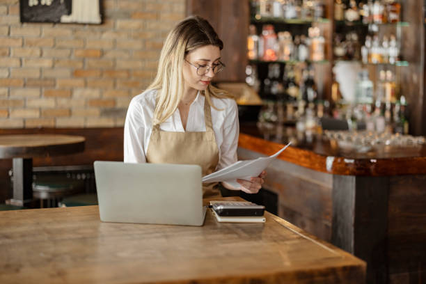 istock Female cafe owner going through financial paperwork 1388423188