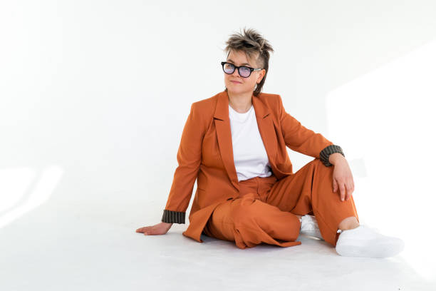 istock young emotional non binary person wearing orange color suit posing at studio 1388426221