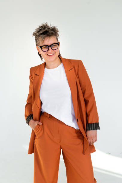 istock young emotional non binary person wearing orange color suit posing at studio 1388427037