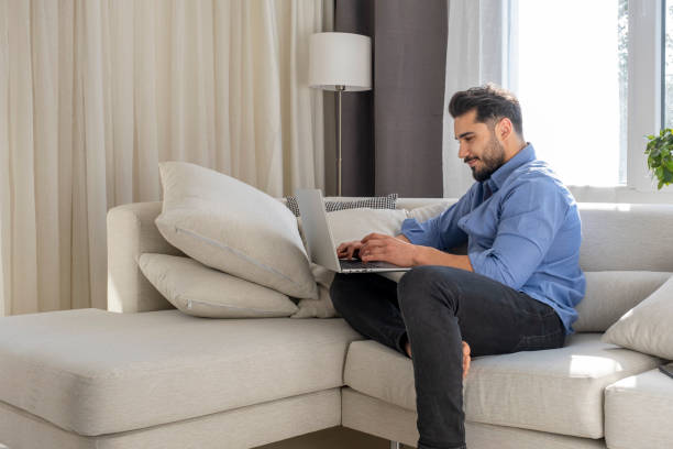 istock Handsome young man having online conversation with laptop 1388427529