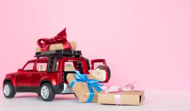 istock red toy car delivering gift boxex present on pink background copy space 1388429992