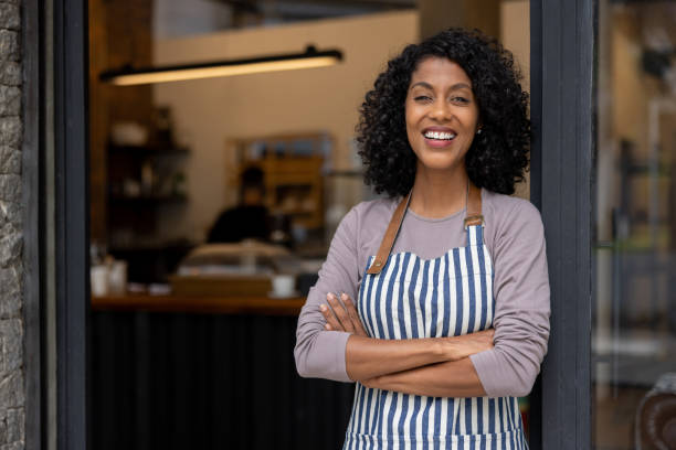 istock Happy waitress standing at the door at a cafe 1388431033