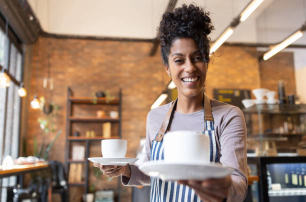 istock Happy waitress serving coffee at a cafe 1388431090