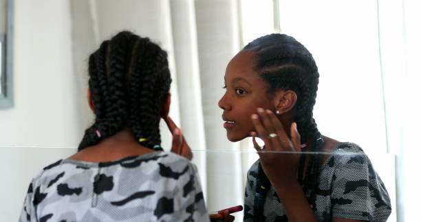 istock Mixed race girl applying makeup in front of mirror 1388431532