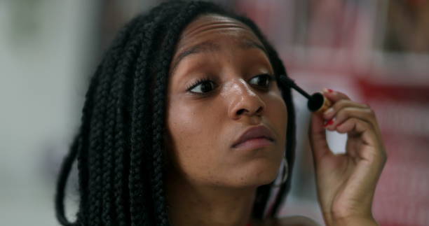 istock Mixed race adolescent girl applying make-up, looking at mirror 1388431646