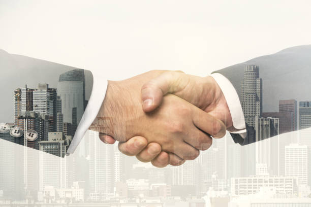 istock Double exposure handshake of two businessmen on office buildings background, collaboration and cooperation concept 1388431663