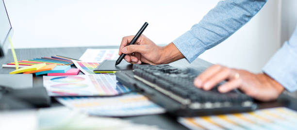 istock Young creative graphic designer working on color selection and drawing on graphics tablet at workplace, Color swatch samples chart for selection coloring 1388432714