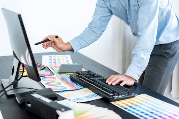 istock Young creative graphic designer working on color selection and drawing on graphics tablet at workplace, Color swatch samples chart for selection coloring 1388432725
