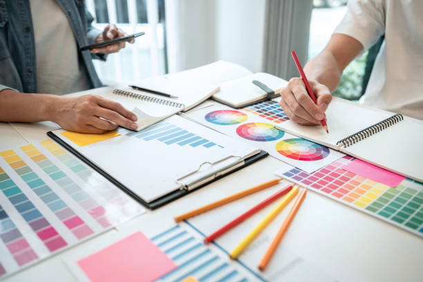 istock Two creative graphic designer working on color selection and drawing on graphics tablet at workplace, Color swatch samples chart 1388432742