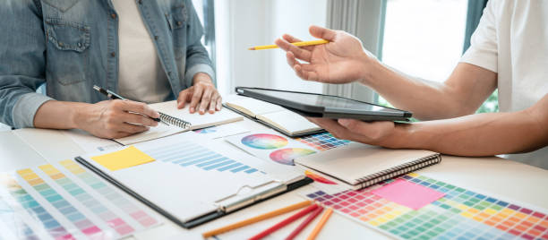 istock Two creative graphic designer working on color selection and drawing on graphics tablet at workplace, Color swatch samples chart 1388432745