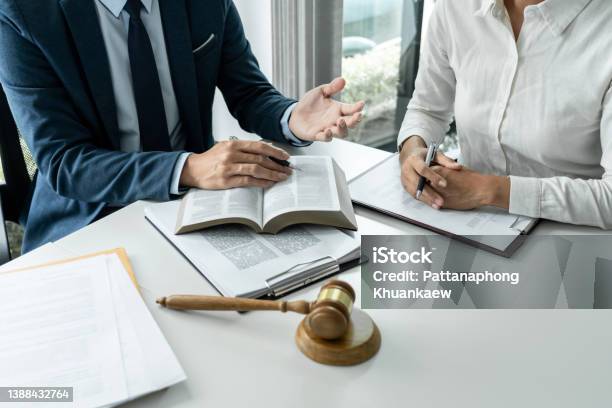 Male Lawyer Is Pointing On Legal Document To Explaining About Consultation Terms And Condition To Businesswoman Before Signing On Contract At Law Firm Stock Photo - Download Image Now