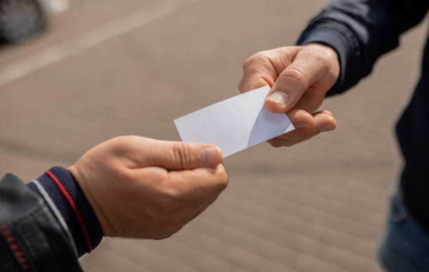 istock Close-up Of two people hands. Exchanging Visiting Card 1388433230