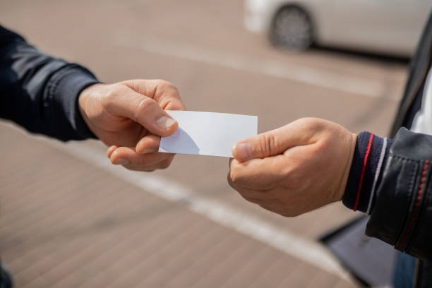 istock Close-up Of two people hands. Exchanging Visiting Card 1388433236
