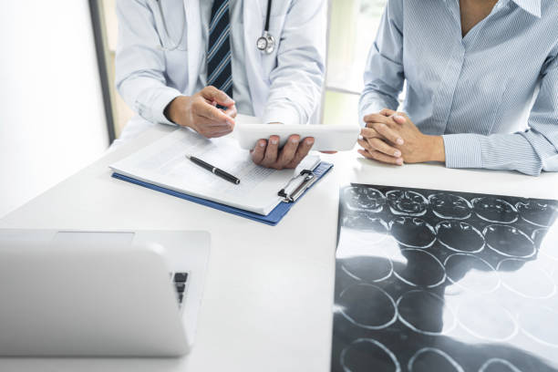 istock Professor Doctor consulting with patient discussing something and recommend treatment methods, Presenting results on report and x-ray film, Medicine and health care concept 1388434654