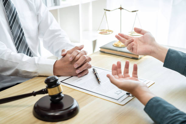 Male lawyer counselor are meeting with client to discuss consultation with litigation contract papers document of estate working in workplace, Law and Legal services concept stock photo