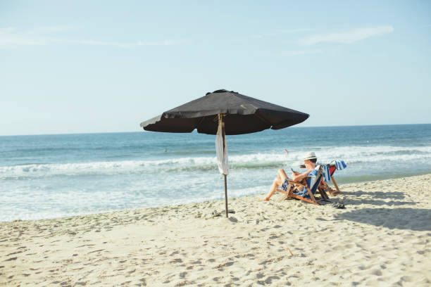 浜辺で読書をしている男 - reading beach e reader men ストックフォトと画像