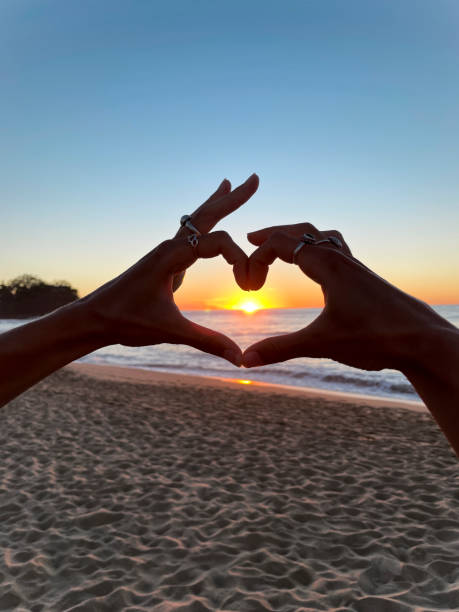 istock Hands forming a heart shape with sunset in background 1388435774