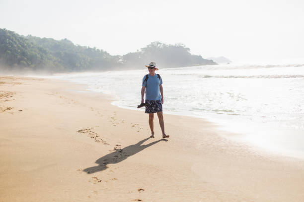 Mature man walking on the beach stock photo