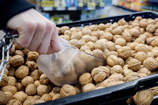 Woman's hand picking up nuts in the supermarket