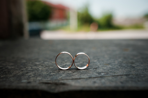 Pair of gold wedding rings on background