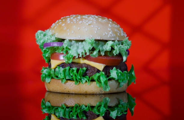 istock Classic Hamburger with Vegetables and Cheese on the Red Reflected Light in the Form of a Window. 1388442123