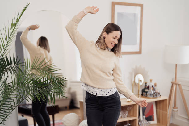 istock Beautiful young woman dancing joyful at home 1388444681